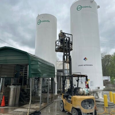 Employee Actively Cleaning Oxygen Tanks in Chattanooga TN by QualityPRO Power Washing