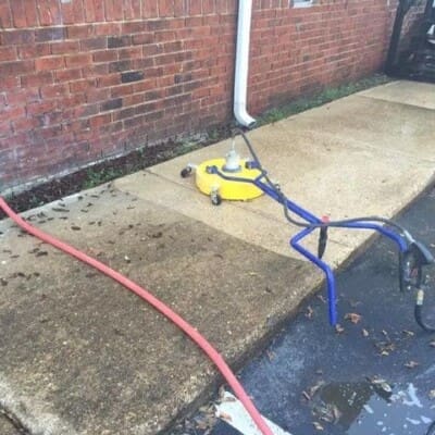 In Action Pressure Washing of Sidewalk and Brick building in Chattanooga TN by QualityPRO Power Washing