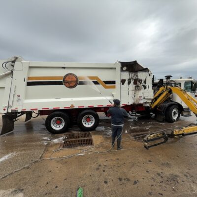 In Action Shot of Employee Cleaning The Logo and Wording on the side of a City of Chatt Garbage Truck in Chattanooga TN by QualityPRO Power Washing