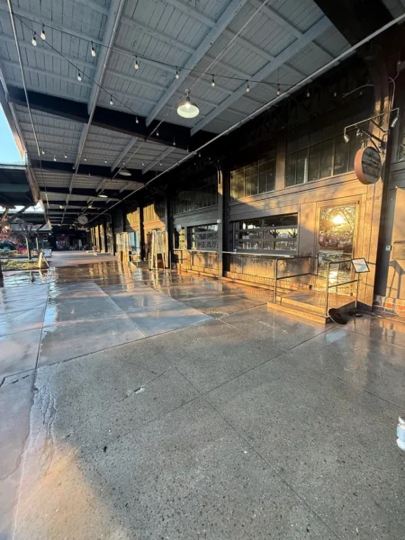 Commercial concrete pressure washing completed at a building entrance, removing heavy dirt and grime buildup to restore a cleaner, brighter, and safer walkway.