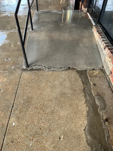 Commercial concrete pressure washing completed at a building entrance, removing heavy dirt and grime buildup to restore a cleaner, brighter, and safer walkway.