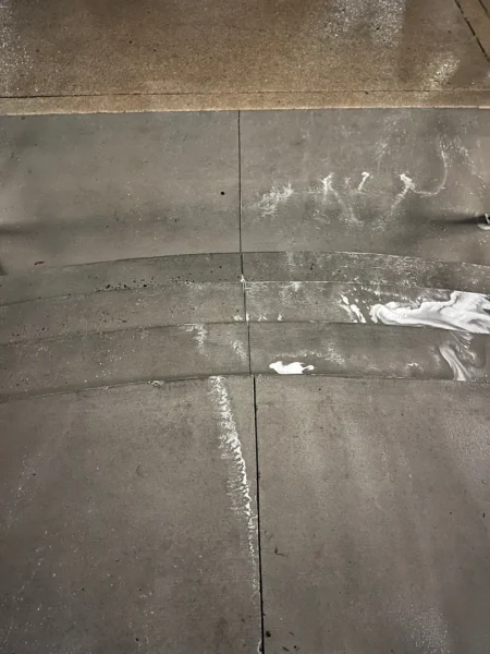Commercial concrete pressure washing completed at a building entrance, removing heavy dirt and grime buildup to restore a cleaner, brighter, and safer walkway.