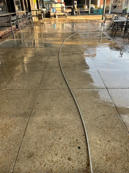 Commercial concrete pressure washing completed at a building entrance, removing heavy dirt and grime buildup to restore a cleaner, brighter, and safer walkway.
