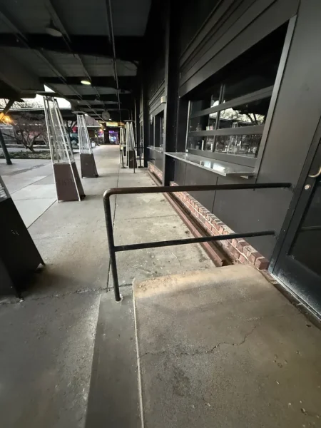 Commercial concrete pressure washing completed at a building entrance, removing heavy dirt and grime buildup to restore a cleaner, brighter, and safer walkway.