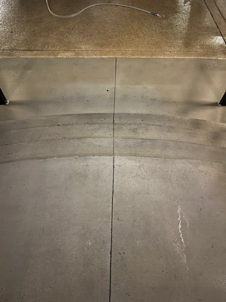 Commercial concrete pressure washing completed at a building entrance, removing heavy dirt and grime buildup to restore a cleaner, brighter, and safer walkway.