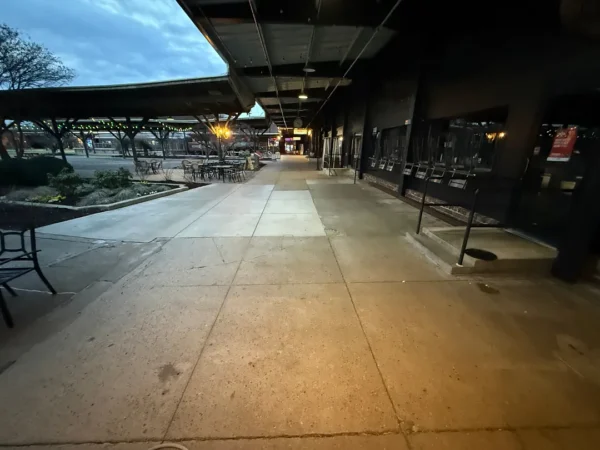 Commercial concrete pressure washing completed at a building entrance, removing heavy dirt and grime buildup to restore a cleaner, brighter, and safer walkway.