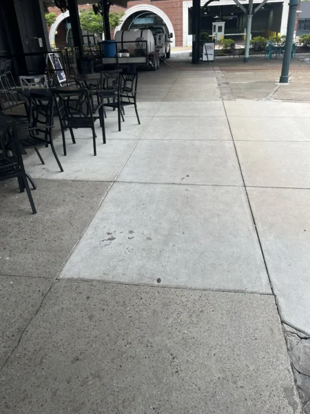 Commercial concrete pressure washing completed at a building entrance, removing heavy dirt and grime buildup to restore a cleaner, brighter, and safer walkway.
