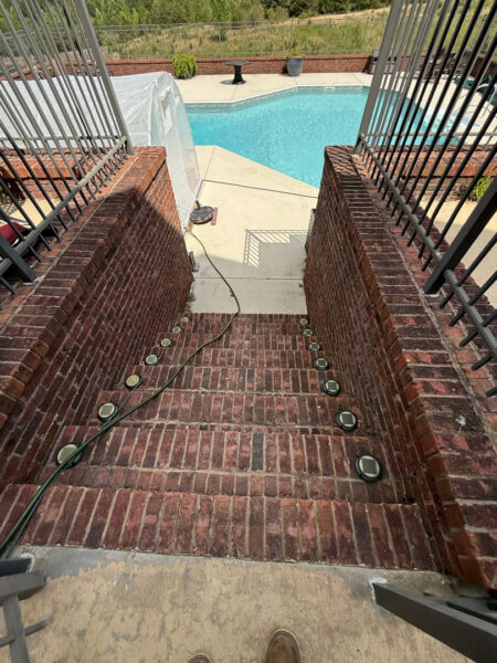 This comprehensive exterior restoration in Soddy-Daisy utilized professional soft-wash and pressure washing techniques to clean the home's siding, concrete surfaces, pool deck, three wood decks, patio furniture, retaining walls, and both interior and exterior windows.