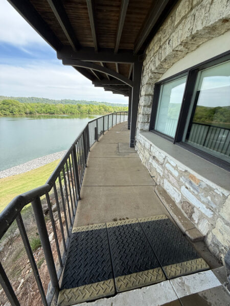 This Chattanooga project utilized surface and soft washing techniques to deep clean the rear walkway, under-deck concrete, and 1896 bar patio while specifically removing red clay stains from the chimney and retaining walls.