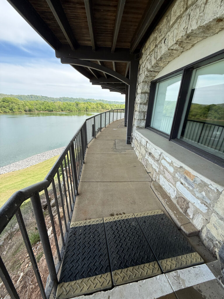 This Chattanooga project utilized surface and soft washing techniques to deep clean the rear walkway, under-deck concrete, and 1896 bar patio while specifically removing red clay stains from the chimney and retaining walls.