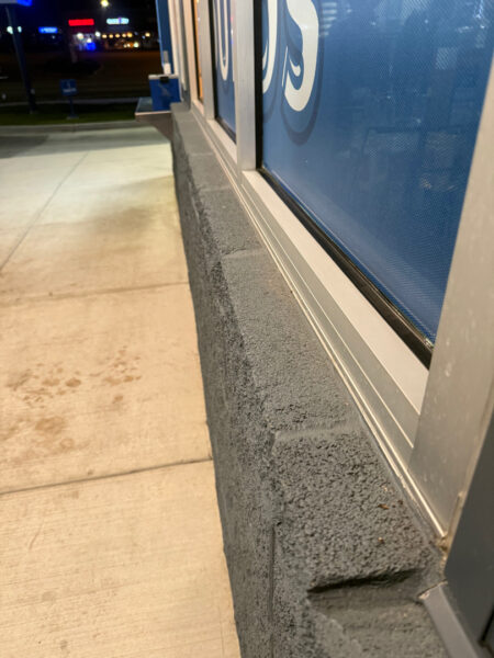 This commercial building in Chattanooga receives a biannual, low-pressure soft wash treatment to remove organic growth and debris from its masonry facade while preserving the integrity of the structure.