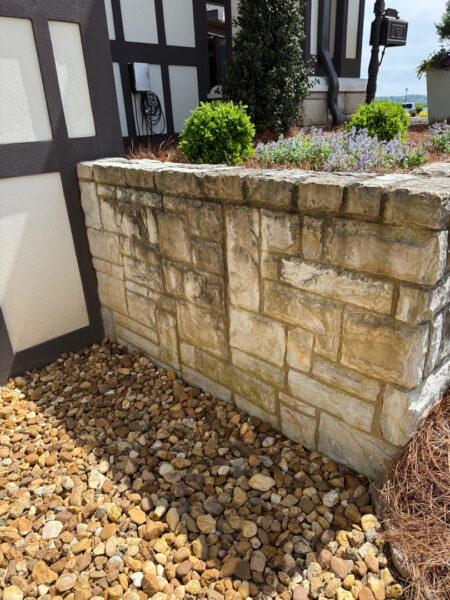 This Chattanooga project utilized surface and soft washing techniques to deep clean the rear walkway, under-deck concrete, and 1896 bar patio while specifically removing red clay stains from the chimney and retaining walls.