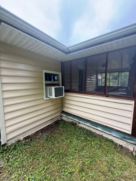This project involved a comprehensive low-pressure soft wash of a single-story home's exterior surfaces, including siding, trim, and gutters, to remove organic growth and restore a uniform appearance.