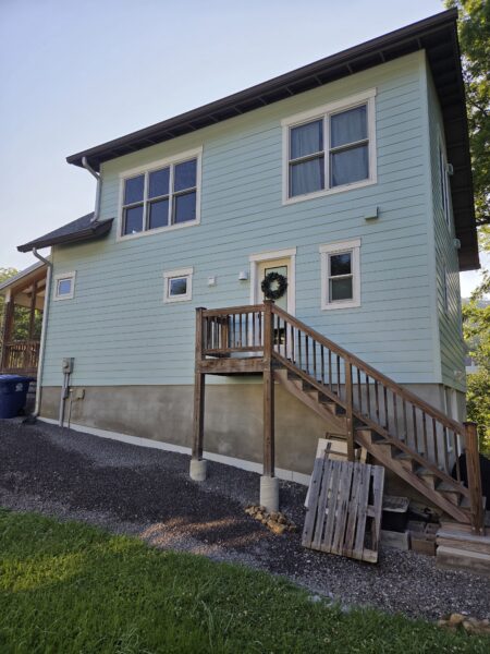Using low-pressure soft washing methods, this project completed a full exterior refresh of a two-story home in Chattanooga, which included cleaning the house siding, front porch and back steps, washing the metal roof, and clearing and flushing the gutter system.