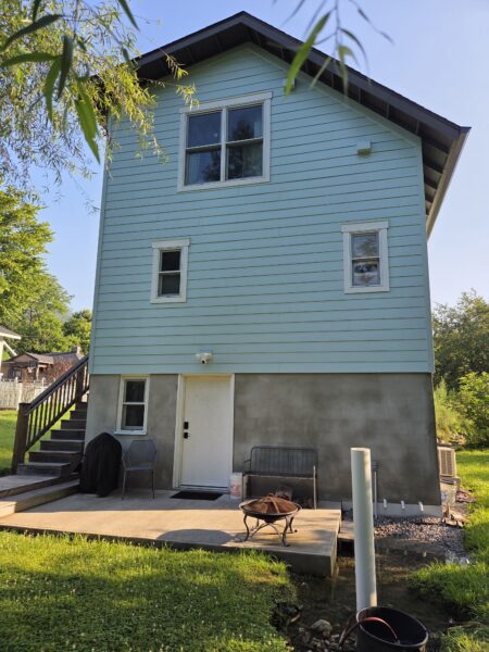 Using low-pressure soft washing methods, this project completed a full exterior refresh of a two-story home in Chattanooga, which included cleaning the house siding, front porch and back steps, washing the metal roof, and clearing and flushing the gutter system.