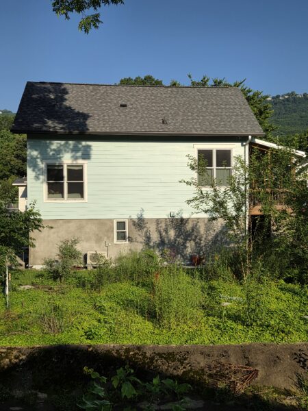 Using low-pressure soft washing methods, this project completed a full exterior refresh of a two-story home in Chattanooga, which included cleaning the house siding, front porch and back steps, washing the metal roof, and clearing and flushing the gutter system.