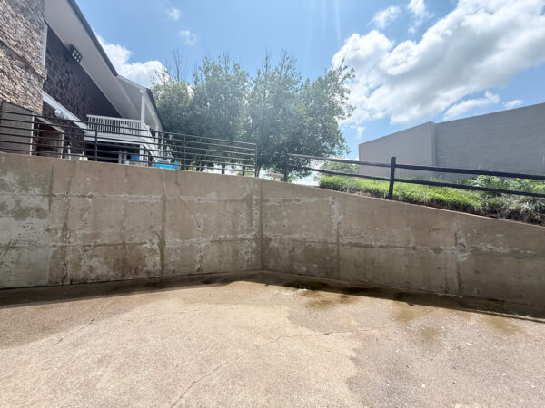 This commercial project in Chattanooga involved a comprehensive soft wash and surface cleaning of a masonry retaining wall, building exteriors, and pedestrian access areas to remove organic growth while protecting on-site fire safety equipment.