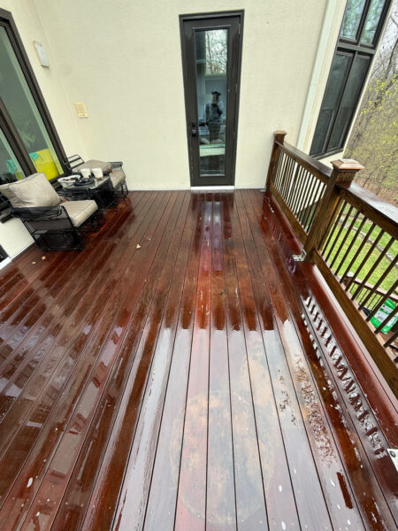 The work performed consists of soft washing and rinsing the primary structure's exterior surfaces, three rear decks, a treehouse with its decks and bridges, and surface cleaning the concrete flatwork, all backed by a one-year warranty against mold and mildew regrowth.