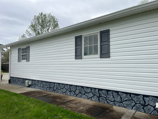 Professional soft wash exterior cleaning will be performed on the main house, porches, and three garage buildings, targeting all vertical surfaces and roofline components to remove organic growth and debris with a one-year warranty.