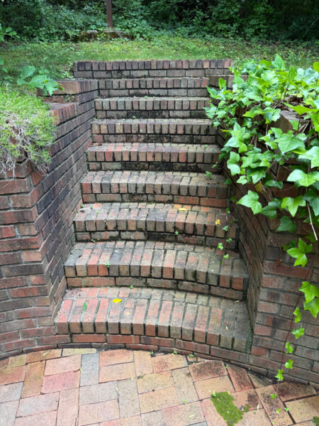 This project involved a comprehensive exterior cleaning of a Chattanooga residence's retaining wall, patio pavers, driveway, and front porch using specialized detergents and pressure washing to remove organic growth and surface debris.
