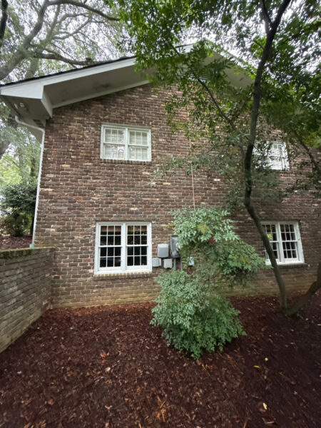 This project involved a comprehensive soft wash and detailed exterior cleaning of a Chattanooga residence, encompassing the house, porches, concrete surfaces, gutters, and outbuildings to remove organic buildup and restore a uniform appearance.