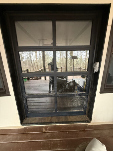 The work performed consists of soft washing and rinsing the primary structure's exterior surfaces, three rear decks, a treehouse with its decks and bridges, and surface cleaning the concrete flatwork, all backed by a one-year warranty against mold and mildew regrowth.