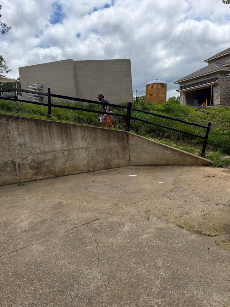 This commercial project in Chattanooga involved a comprehensive soft wash and surface cleaning of a masonry retaining wall, building exteriors, and pedestrian access areas to remove organic growth while protecting on-site fire safety equipment.