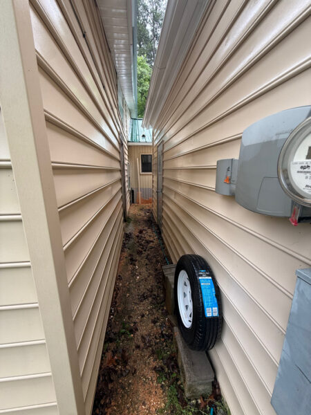 This project involved a comprehensive low-pressure soft wash of a single-story home's exterior surfaces, including siding, trim, and gutters, to remove organic growth and restore a uniform appearance.