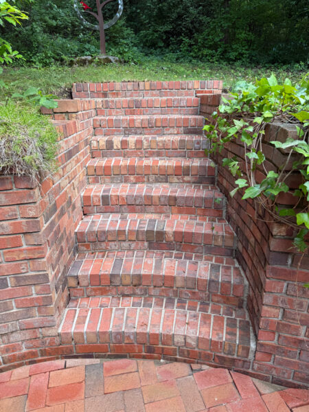 This project involved a comprehensive exterior cleaning of a Chattanooga residence's retaining wall, patio pavers, driveway, and front porch using specialized detergents and pressure washing to remove organic growth and surface debris.