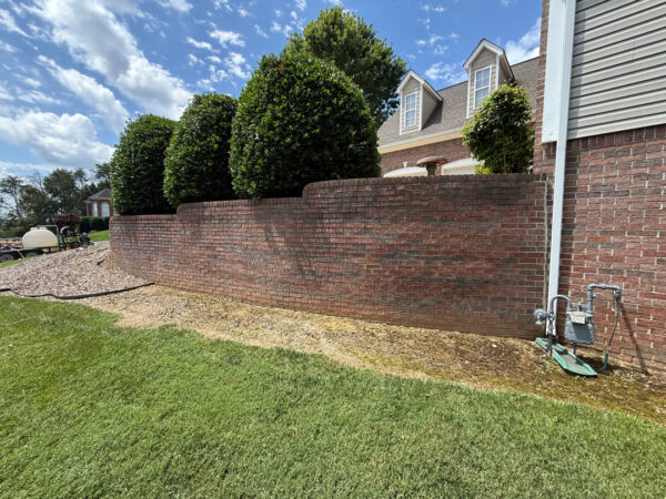 This project involved a comprehensive soft wash and gentle scrubbing of a two-story home's exterior, front steps, retaining wall, and covered back porch in Apison to remove organic buildup and grime, backed by a 1-year mold and mildew warranty.