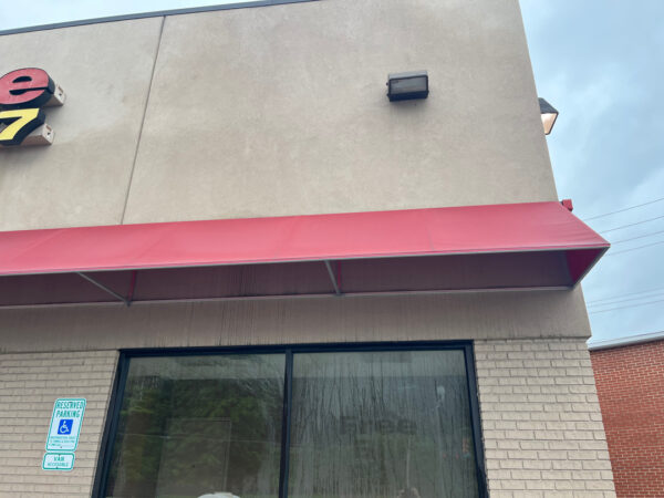 The team performed a specialized low-pressure soft wash on a commercial awning system and a professional power wash on adjacent concrete surfaces in Chattanooga to remove organic growth and restore the property's curb appeal.
