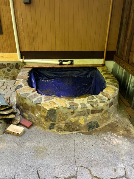 This project involved the soft washing of a one-story residence's exterior, its driveway and walkway pavers, and a stone fountain, alongside the cleaning of a commercial metal roof, to remove organic growth and restore the appearance of all surfaces in McDonald.