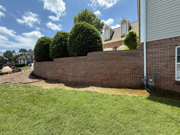 This project involved a comprehensive soft wash and gentle scrubbing of a two-story home's exterior, front steps, retaining wall, and covered back porch in Apison to remove organic buildup and grime, backed by a 1-year mold and mildew warranty.