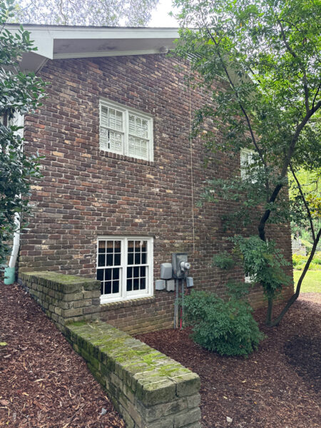 This project involved a comprehensive soft wash and detailed exterior cleaning of a Chattanooga residence, encompassing the house, porches, concrete surfaces, gutters, and outbuildings to remove organic buildup and restore a uniform appearance.