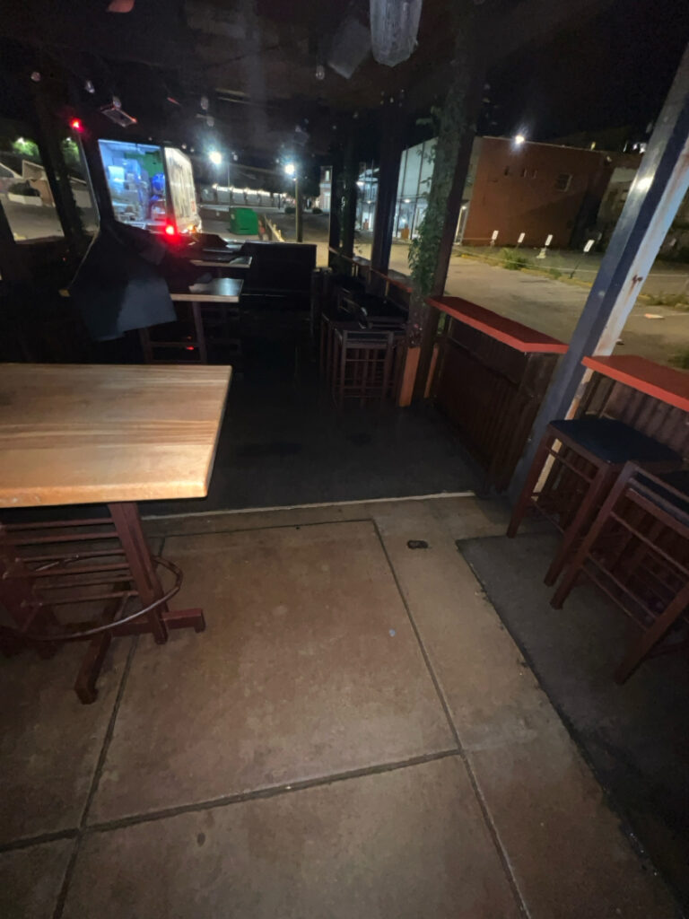 This project involved pressure washing a Chattanooga restaurant's front sidewalk, customer patio, and dumpster area using a municipal fire hydrant water source to remove dirt, stains, and grease for a cleaner appearance.