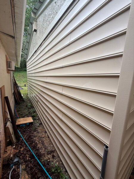 This project involved a comprehensive low-pressure soft wash of a single-story home's exterior surfaces, including siding, trim, and gutters, to remove organic growth and restore a uniform appearance.