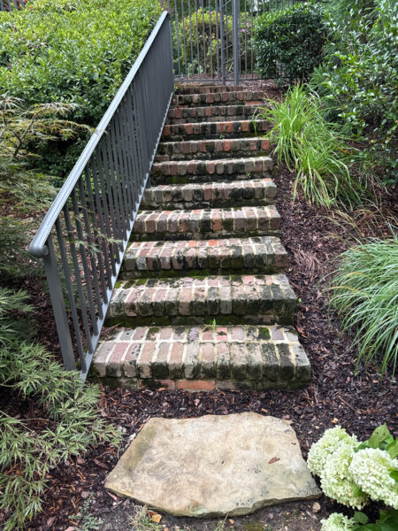 This project involved a comprehensive soft wash and detailed exterior cleaning of a Chattanooga residence, encompassing the house, porches, concrete surfaces, gutters, and outbuildings to remove organic buildup and restore a uniform appearance.