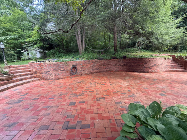 This project involved a comprehensive exterior cleaning of a Chattanooga residence's retaining wall, patio pavers, driveway, and front porch using specialized detergents and pressure washing to remove organic growth and surface debris.
