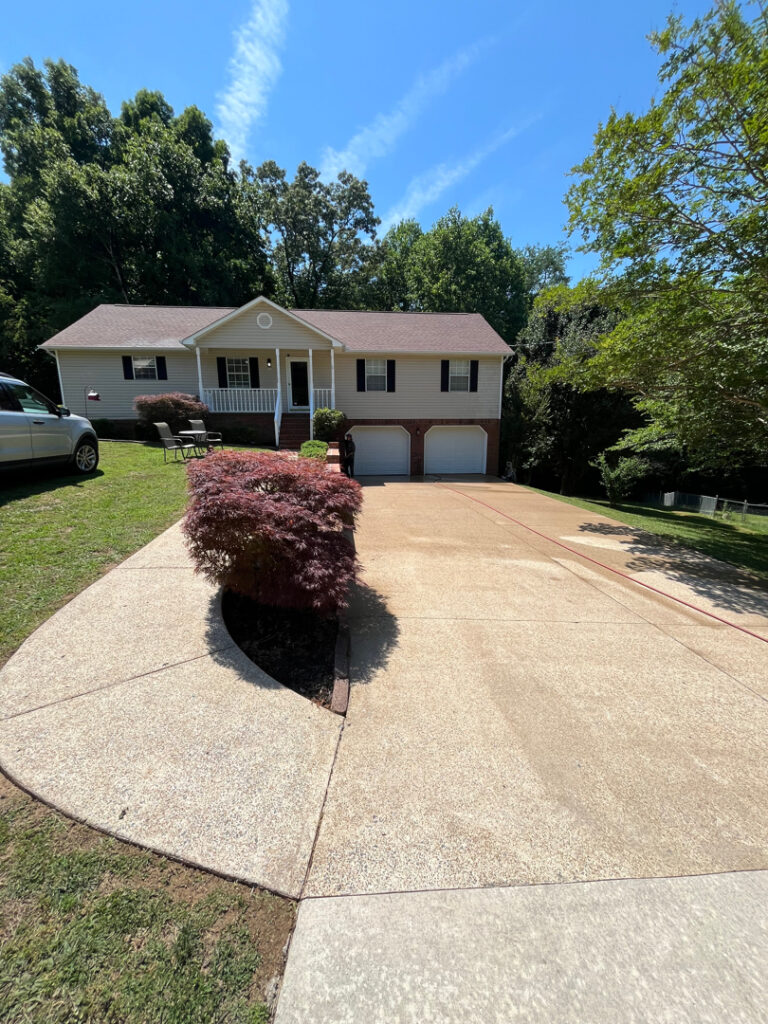 This project involved a comprehensive soft wash of the home's exterior and screened porch, complemented by surface cleaning of the concrete driveway, walkways, and a retaining wall to remove organic growth and debris.