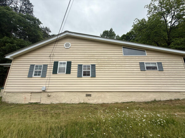 This project involved a comprehensive low-pressure soft wash of a single-story home's exterior surfaces, including siding, trim, and gutters, to remove organic growth and restore a uniform appearance.