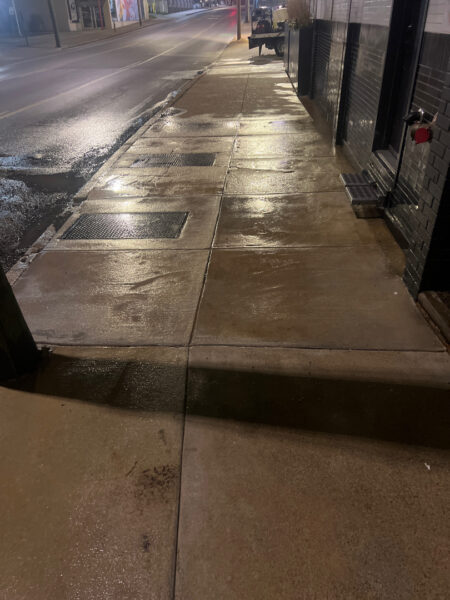 The front patio concrete at Milk and Honey was professionally restored through a multi-step process involving site protection, specialized detergent application, targeted pressure washing, and a final rinse to remove organic growth and grease.