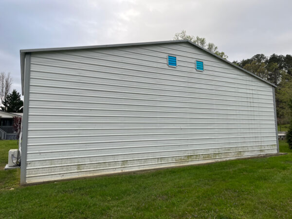 Professional soft wash exterior cleaning will be performed on the main house, porches, and three garage buildings, targeting all vertical surfaces and roofline components to remove organic growth and debris with a one-year warranty.