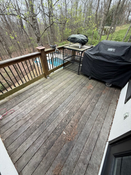 The work performed consists of soft washing and rinsing the primary structure's exterior surfaces, three rear decks, a treehouse with its decks and bridges, and surface cleaning the concrete flatwork, all backed by a one-year warranty against mold and mildew regrowth.