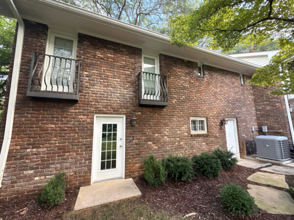 This project involved a comprehensive soft wash and detailed exterior cleaning of a Chattanooga residence, encompassing the house, porches, concrete surfaces, gutters, and outbuildings to remove organic buildup and restore a uniform appearance.