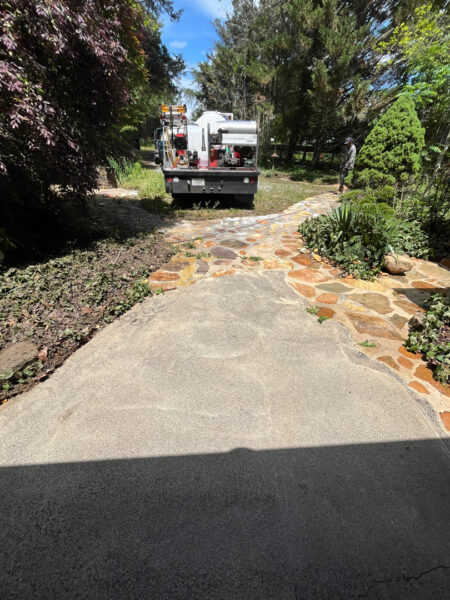 This project involved the soft washing of a one-story residence's exterior, its driveway and walkway pavers, and a stone fountain, alongside the cleaning of a commercial metal roof, to remove organic growth and restore the appearance of all surfaces in McDonald.