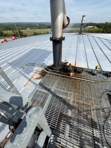 This project involved the complete cleaning and surface preparation of two industrial storage tanks' tops and upper walls using a 40-foot electric lift, pressure washing, and specialized detergents to remove mold, mildew, and dirt.
