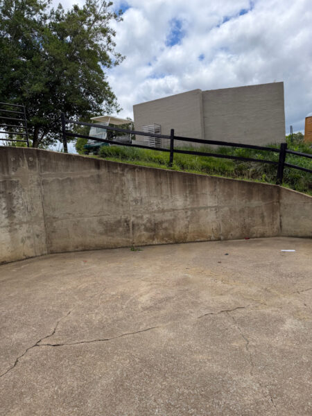 This commercial project in Chattanooga involved a comprehensive soft wash and surface cleaning of a masonry retaining wall, building exteriors, and pedestrian access areas to remove organic growth while protecting on-site fire safety equipment.