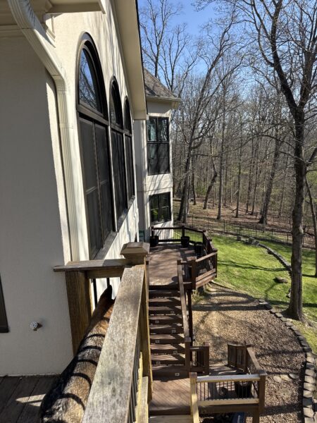 The work performed consists of soft washing and rinsing the primary structure's exterior surfaces, three rear decks, a treehouse with its decks and bridges, and surface cleaning the concrete flatwork, all backed by a one-year warranty against mold and mildew regrowth.