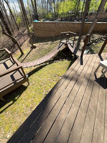 The work performed consists of soft washing and rinsing the primary structure's exterior surfaces, three rear decks, a treehouse with its decks and bridges, and surface cleaning the concrete flatwork, all backed by a one-year warranty against mold and mildew regrowth.