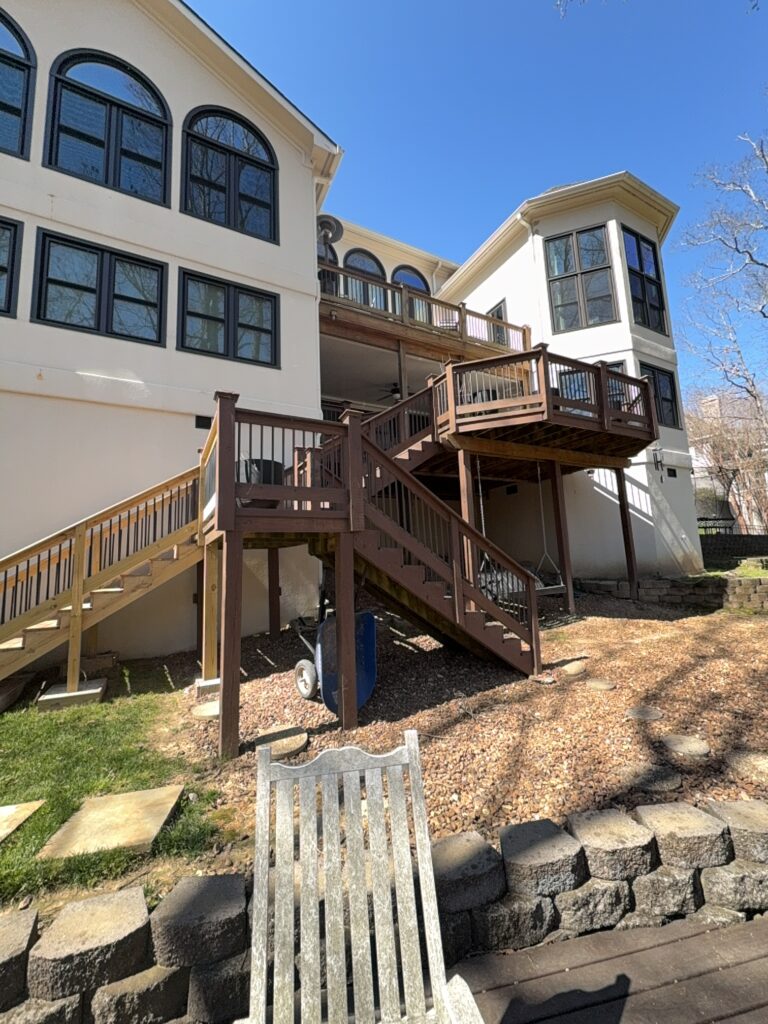 The work performed consists of soft washing and rinsing the primary structure's exterior surfaces, three rear decks, a treehouse with its decks and bridges, and surface cleaning the concrete flatwork, all backed by a one-year warranty against mold and mildew regrowth.